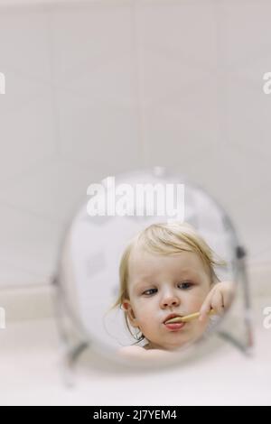 piccola ragazza divertente spazzolando i denti in bagno. Foto Stock