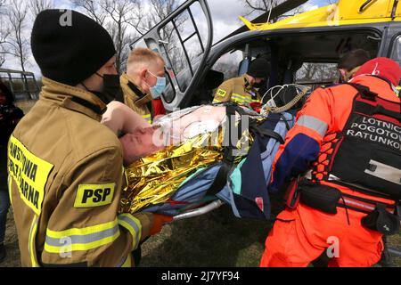 Cracovia. Cracovia. Polonia. Paramedici e vigili del fuoco caricano il paziente su un elicottero di salvataggio aereo durante l'esercizio di addestramento del casua di massa simulato Foto Stock