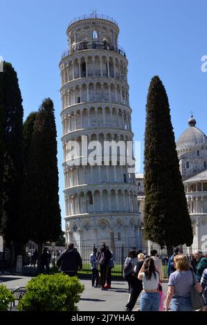 Pisa, Italia - 17 Aprile 2022: Torre pendente di pisa e palazzi in una soleggiata giornata primaverile Foto Stock