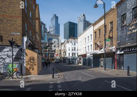 Vista lungo Wentworth Street che contrasta con i moderni e alti uffici della City di Londra con i vecchi edifici del 19th secolo. Foto Stock