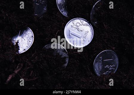 Moneta nel terreno. Soldi sparsi a terra. Il deprezzamento del rublo. La caduta della valuta. Variazione del tasso di cambio. Foto Stock