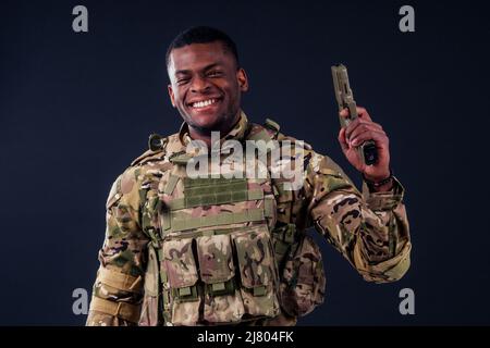 uomo americano in camouflage vestito mirante con una pistola Foto Stock