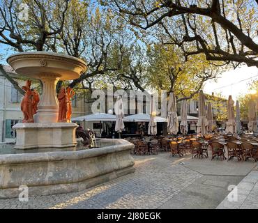 Fontana d'acqua e caffè posti a sedere nella piazza del villaggio, Maussane-les-Alpilles, Bouches-du-Rhone, Provenza-Alpi-Costa Azzurra, Francia Foto Stock