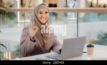 Fiducioso musulmana businesswoman freelancer nel lavoro hijab digitando su laptop chattare fa acquisti in negozio online ragazza studente studiare in remoto Foto Stock