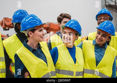 Ingegneri multietnici che lavorano insieme all'interno di impianti di automazione e robotica - nuovo concetto di tecnologia industriale Foto Stock