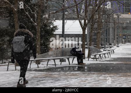 NEW YORK, N.Y. – 18 febbraio 2021: Le persone sono viste vicino al terminal dei traghetti di Staten Island a Lower Manhattan durante una tempesta invernale. Foto Stock