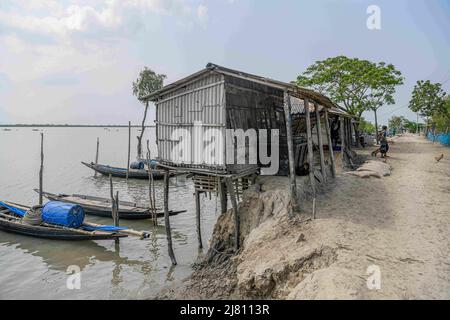 Satkhira, Bangladesh. 6th maggio 2022. A causa dell'erosione del fiume, una strada è rotta, una casa è visto in piedi a rischio sulla riva del fiume Kholpatua nella zona costiera vicino Sundorban a Satkhira. (Credit Image: © Piyas Biswas/SOPA Images via ZUMA Press Wire) Foto Stock