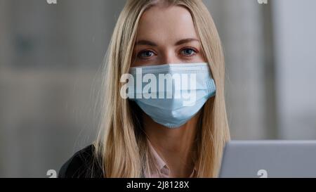 Ritratto caucasian 30s business donna marketing specialista banca lavoratore agente di assicurazione donna con laptop mascherato manager biondo indossa viso Foto Stock