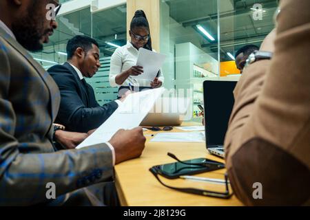 Persona d'affari asiatica in multirazziale. Diversità uomini d'affari formano da diverse razze, indiana, malese, indonesiana, cinese e africana in camera moderna Foto Stock