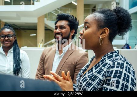 Persona d'affari asiatica in multirazziale. Diversità uomini d'affari formano da diverse razze, indiana, malese, indonesiana, cinese e africana in camera moderna Foto Stock