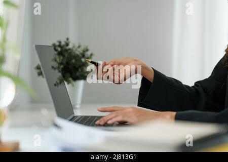 Businesswoman nel fare una videochiamata sul laptop mentre discutete con il socio di affari durante il lavoro dalla sede. Foto Stock