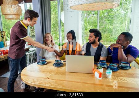 persone internazionali che bevono tè (caffè) in caffetteria Foto Stock