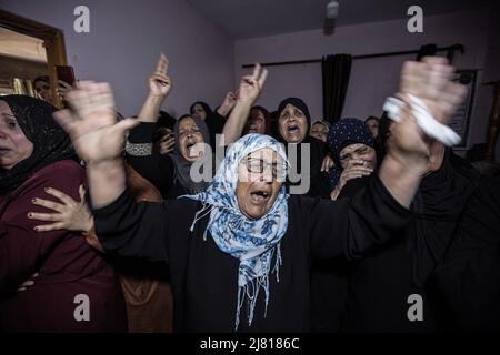 Gaza, Palestina. 11th maggio 2022. I parenti di Mahmoud Aram, 28 anni di lutto durante il suo funerale a Khan Yunis nella striscia meridionale di Gaza. Aram è stato ucciso a colpi di arma da fuoco mentre cercava di attraversare vicino a una barriera di sicurezza controllata da Israele nella Cisgiordania settentrionale, secondo l'IDF poiché gli è stato permesso di trasferirsi in Cisgiordania nel 2019 per essere trattato. (Foto di Yousef Masoud/SOPA Images/Sipa USA) Credit: Sipa USA/Alamy Live News Foto Stock