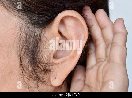 Orecchio di anziana asiatica con sordità. Concetto di tenere aperte le orecchie. Foto Stock
