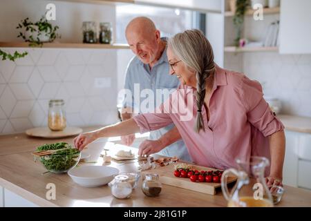 Felice coppia senior che cucinano insieme a casa. Foto Stock