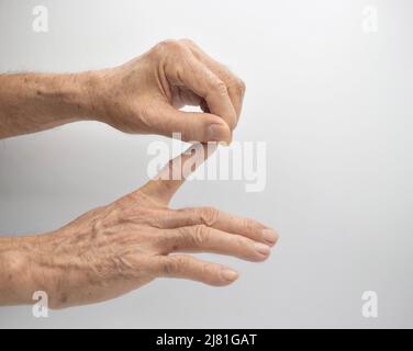 Rafforzare l'esercizio per la salute delle dita di pazienti maschi anziani asiatici con spasmo muscolare. Foto Stock