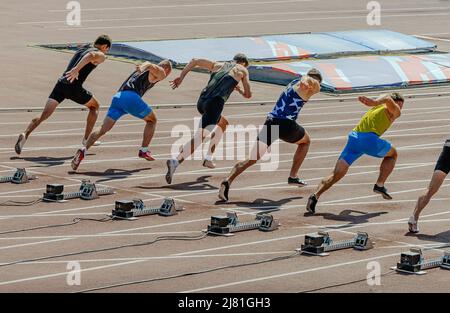 man atleti che iniziano a correre in 100m gara sprint Foto Stock