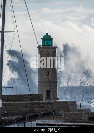Tempesta in mare, onde alte nel vecchio porto di pescatori con faro a Cassis, Provenza, Francia Foto Stock