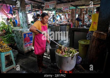 San Jose, Filippine - Maggio 2022: Una donna che prepara il cibo al mercato di San Jose il 3 maggio 2022 a San Jose, Occidental Mindoro, Filippine. Foto Stock