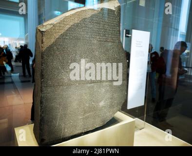 Londra, Regno Unito. 11th maggio 2022. Foto scattata il 11 maggio 2022 mostra la pietra Rosetta nel British Museum di Londra, Gran Bretagna. La pietra Rosetta è uno degli oggetti più famosi del British Museum. La pietra è una parte rotta di una lastra di pietra più grande. Ha un messaggio scolpito in esso, scritto in tre tipi di scrittura. Era un indizio importante che aiutava gli esperti ad imparare a leggere i geroglifici egiziani (un sistema di scrittura che usava le immagini come segni). Credit: Li Ying/Xinhua/Alamy Live News Foto Stock