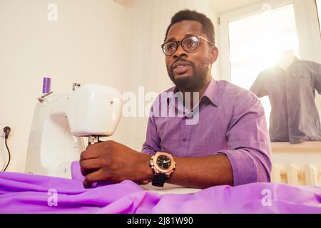 uomo su misura laboratorio marinaio elegante modello maschile abiti designer il processo di creazione di una nuova collezione di abiti da sposa in casa studio Foto Stock