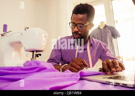 happy uomo africano progettista ingegnere costruttore scrivere idee in un notebook in studio Foto Stock