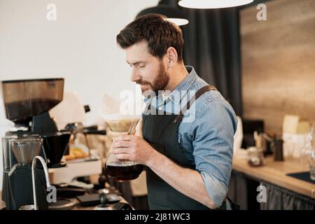 Bel barista con elegante caffè filtro profumato alla barba in caffetteria Foto Stock