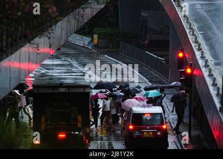 Hong Kong, Cina. 12th maggio 2022. La gente attraversa una strada sotto la pioggia pesante. Giovedì ad Hong Kong sono previste forti piogge e temporali occasionali. (Credit Image: © Keith Tsuji/ZUMA Press Wire) Foto Stock