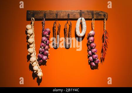 Vecchia salsiccia e asciugatrice di verdure su sfondo arancione Foto Stock