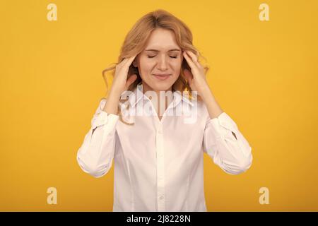 Donna infelice regista soffre di emicrania attacco sfondo giallo, mal di testa Foto Stock