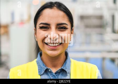 Happy ingegnere donna che lavora all'interno di una fabbrica robotica - concetto industriale e tecnologico - Focus principale sugli occhi Foto Stock