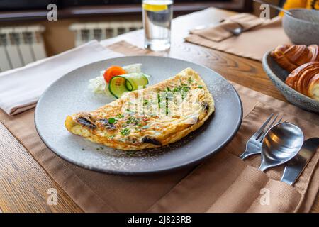 Deliziosa colazione: Uova strapazzate con cipolla, parmigiano e chorizo su tavola di legno Foto Stock