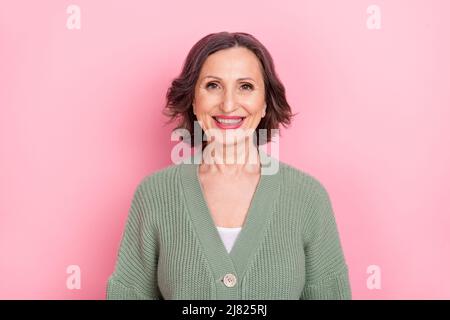 Ritratto di attraente marrone-capelli allegro donna madre mamma indossare cardigan lavorato a maglia isolato su rosa pastello sfondo colore Foto Stock