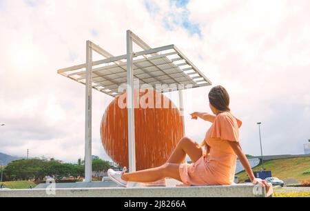 Caracas, Venezuela - 1 maggio 2022. Donna apprezzare l'arte scultura cinetica Esfera Caracas, di Jesus Soto, sulla Francisco Fajardo Highway. Foto Stock