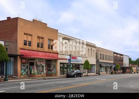 THOMASVILLE, NC, USA-8 MAGGIO 2022: Un blocco di edifici di negozi d'epoca su Main Street. Prospettiva diagonale. Foto Stock