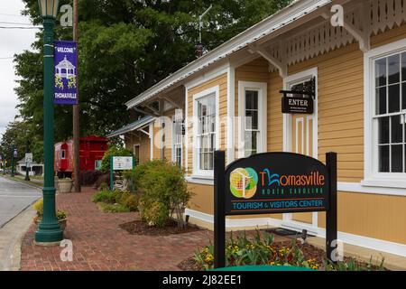 THOMASVILLE, NC, USA-8 MAGGIO 2022: Thomasville Tourism & Visitors Center, segnaletica multipla, caboose rosso, da vicino colorato. Foto Stock