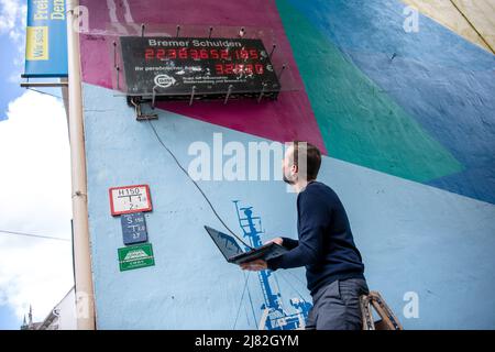 Brema, Germania. 12th maggio 2022. Jan Vermöhlen dell'Associazione dei contribuenti di Brema regola l'orologio del debito BDST in base a nuovi calcoli. Credit: Sina Schuldt/dpa/Alamy Live News Foto Stock