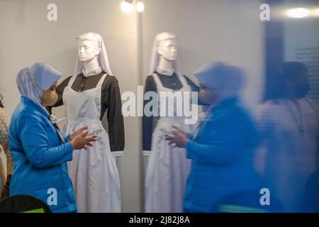 Kuala Lumpur, Malesia. 12th maggio 2022. La gente visita una mostra che mostra l'evoluzione dell'uniforme delle infermiere nella storia della Malesia al Museo Nazionale di Kuala Lumpur, Malesia, 12 maggio 2022. Il 12 maggio segna la Giornata Internazionale delle infermiere. Si tratta di una giornata speciale che si celebra ogni anno per celebrare l'anniversario della nascita di Florence Nightingale e per celebrare i contributi che gli infermieri apportano alla società. Credit: Chong Voon Chung/Xinhua/Alamy Live News Foto Stock