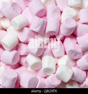 Primo piano di mini marshmallow rosa e bianco spesso utilizzato in ricette stradali rocciose e come un condimento su bevande calde al cioccolato. Foto Stock