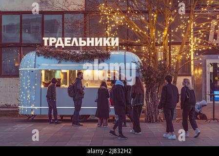 San Pietroburgo, Russia: La gente si trova in fila davanti a un camion alimentare che vende trdelniks (scritto in russo sul cartello del negozio) al porto di Sevkabel. Foto Stock