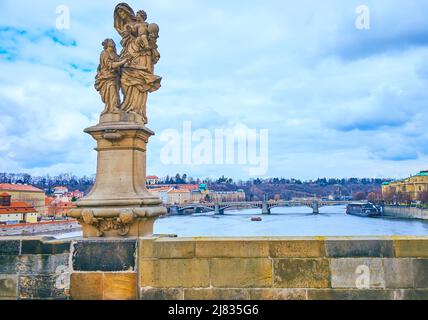 La statua in pietra di Sant'Anna sul Ponte Carlo con il fiume Moldava e il Ponte Manes sullo sfondo, Praga, Repubblica Ceca Foto Stock