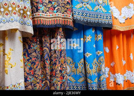 Fenghuang, provincia di Hunan, Cina: Tessuto colorato di abiti in vendita in un negozio di moda a Fenghuang. Profondità di campo bassa su abito blu. Foto Stock