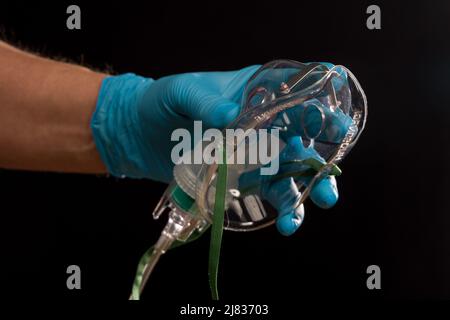 Mano del medico con maschera di ossigeno monouso per il supporto di respirazione Foto Stock