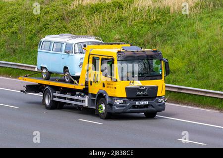 1973 70s Seventies Blue VW Volkswagen kombi Bay window camper furgone trasportato da 2021 giallo UOMO AA car carrier 24hr, soccorso stradale emergenza veicolo di recupero; guida sulla M6 autostrada, Regno Unito Foto Stock