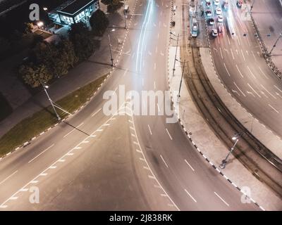 Traffico di trasporto stradale notturno nel centro città. Vista aerea verso il basso sulle vetture che guidano con illuminazione delle luci. Strade del centro di Kharkiv, Ucraina Foto Stock