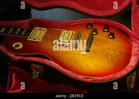 Foto del corpo della chitarra vintage Les Paul presa dal lato. La chitarra è in una custodia abbronzata con interno in feltro rosa. Foto Stock