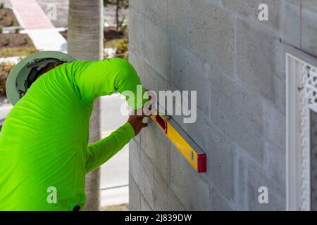il lavoratore di costruzione sta realizzando una linea orizzontale per l'installazione di una bordatura angolare per l'installazione di stucco. Foto Stock