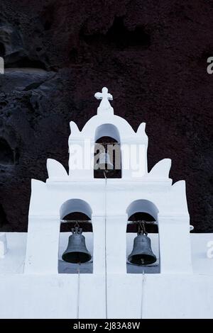 Il campanile bianco su sfondo vulcano di roccia nera Foto Stock