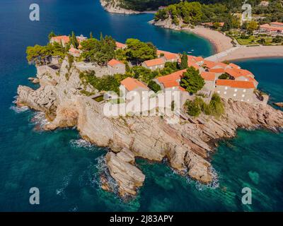 Aerofotografia. Vista dal drone volante. Vista panoramica dell'isola di Sveti Stefan a Budva in una splendida giornata estiva, Montenegro. Vista dall'alto. Bellissima Foto Stock