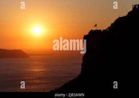 Tramonto sul mare Egeo e roccia sull'isola di Santorini, Grecia Foto Stock